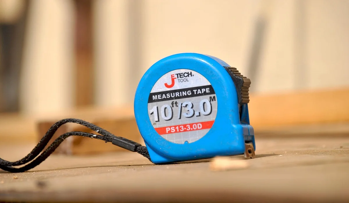 Blue measuring tape on a wooden work surface for precise measurements
