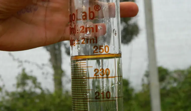Close-up of a glass hydrometer inside a graduated cylinder, used to measure GH and KH in aquarium water
