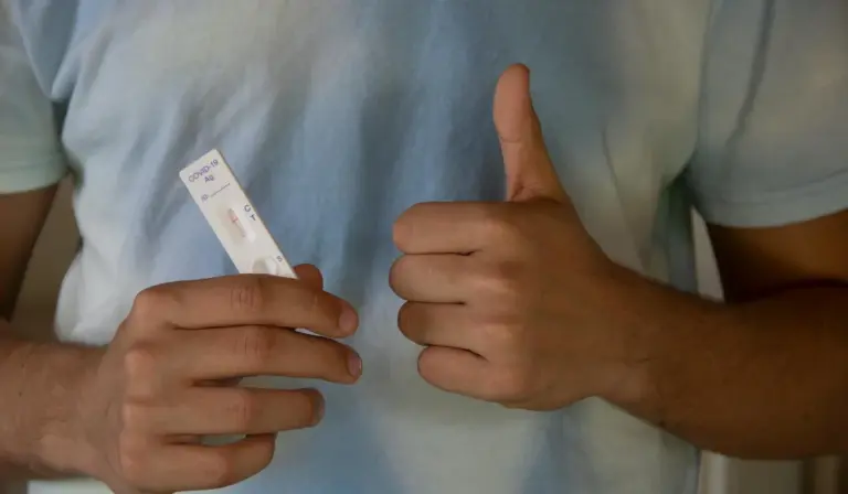 Person holding an aquarium test strip and giving a thumbs up