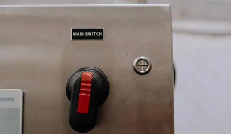 Close-up of a stainless steel electrical panel with a red main power switch labeled 'MAIN SWITCH'.