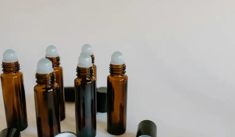 Several amber glass bottles with white dropper caps arranged on a light background.