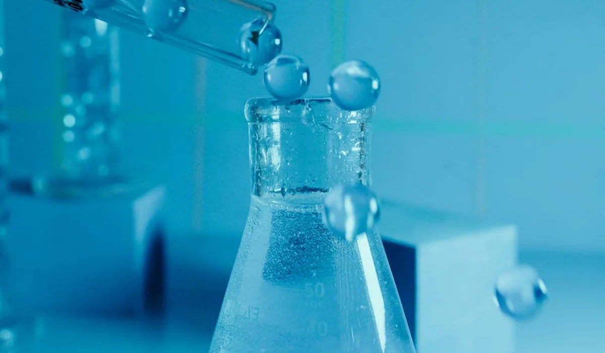 Close-up of glassware releasing CO2 bubbles into a liquid, illustrating carbon dioxide diffusion in a planted aquarium