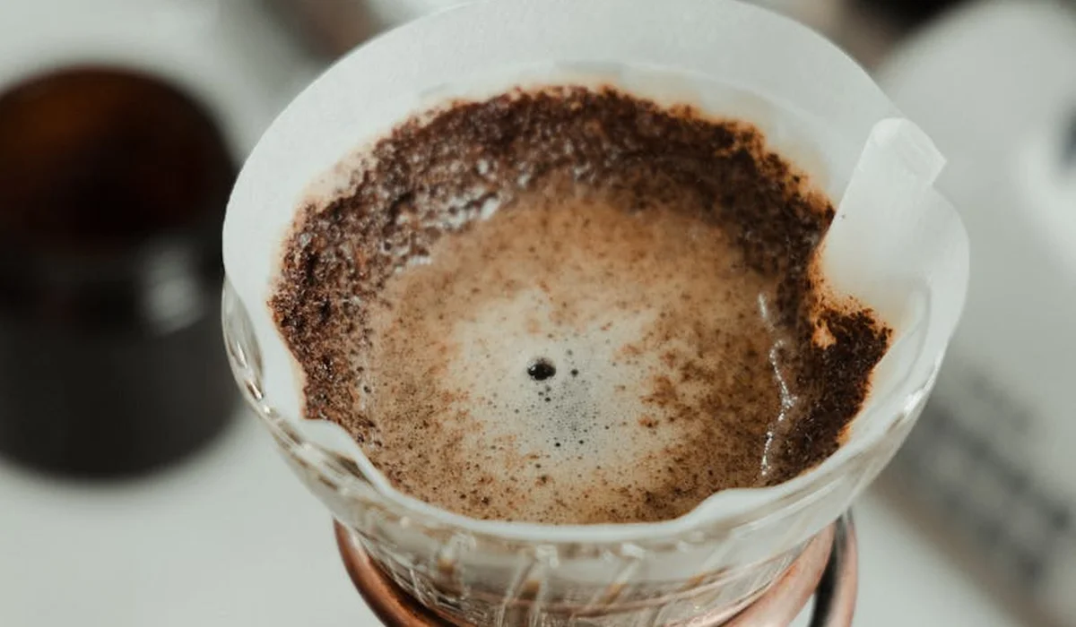 Close-up of a coffee pour-over filter with coffee grounds forming a ring around the filter.