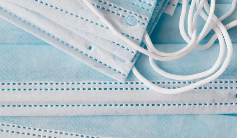 Close-up of blue disposable surgical masks with white ear loops