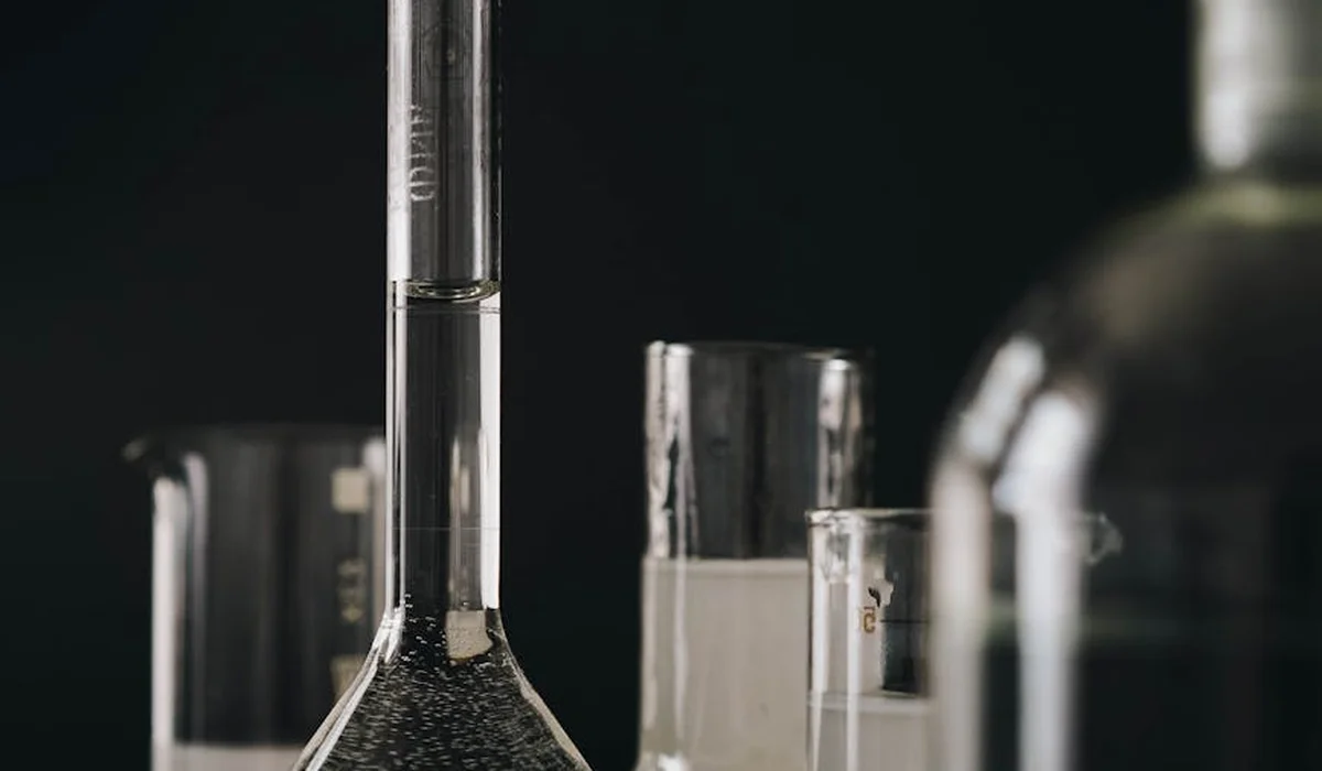 Laboratory glassware, including a conical flask and test tubes, with clear water for demonstrating precise water parameter testing