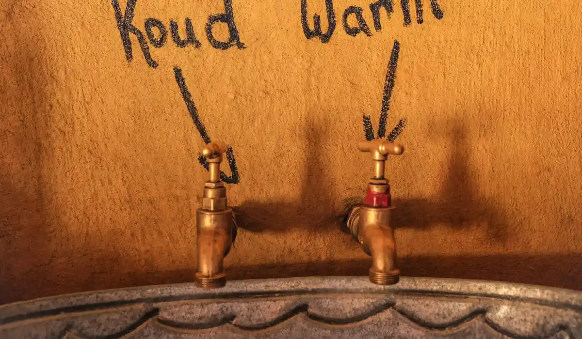 Two vintage taps labeled 'Koud' and 'Warm' mounted above a barrel.