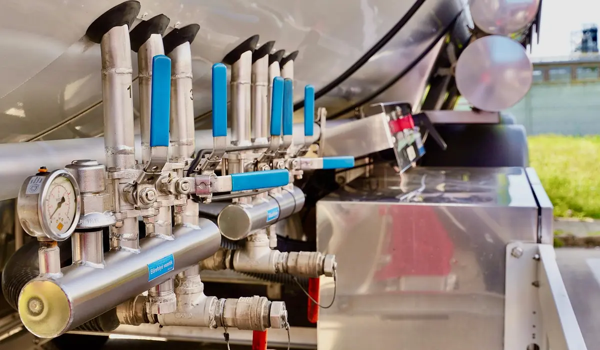 Close-up of an aquarium filtration manifold with blue-handled valves and stainless fittings, illustrating the tools used to control water flow and manage TDS.