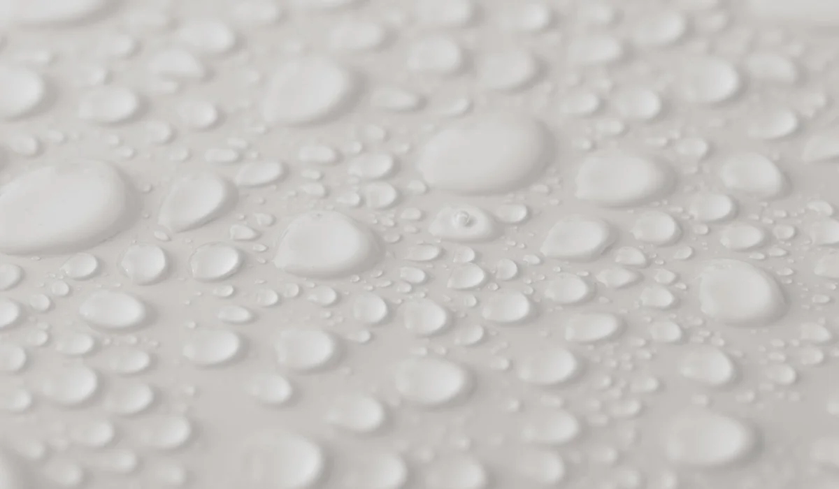 Close-up of water droplets on a white surface, illustrating moisture considerations for aquarium electrical safety.
