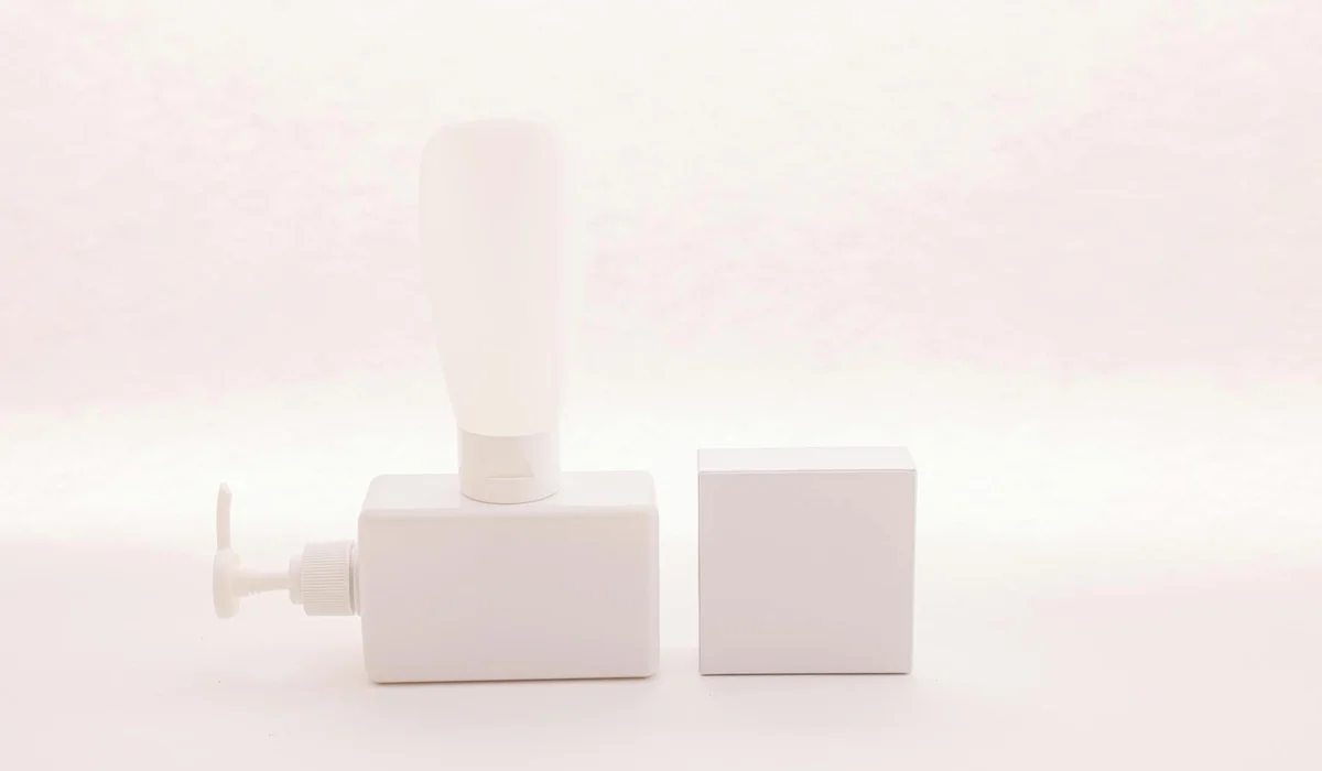 White aquarium pump components on a pale background, with the pump body on the left and a small square block nearby.