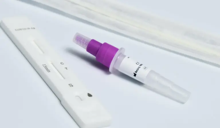 Aquarium water testing kit with a test strip card and a purple-capped dropper bottle on a light surface.