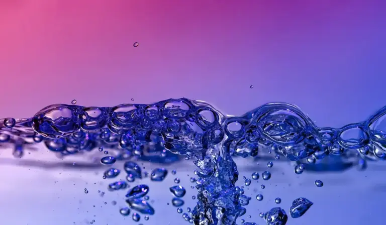 Blue bubbles rising through clear water with a purple-pink gradient background, illustrating oxygenation in an aquarium