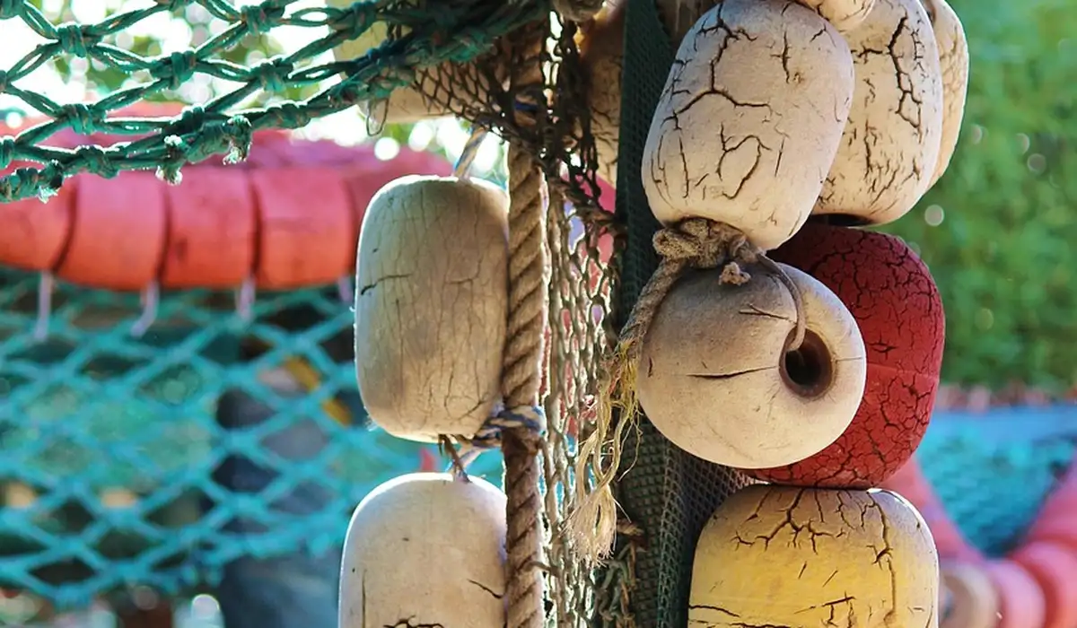Colorful fishing buoys and tangled rope hanging against a softly blurred background
