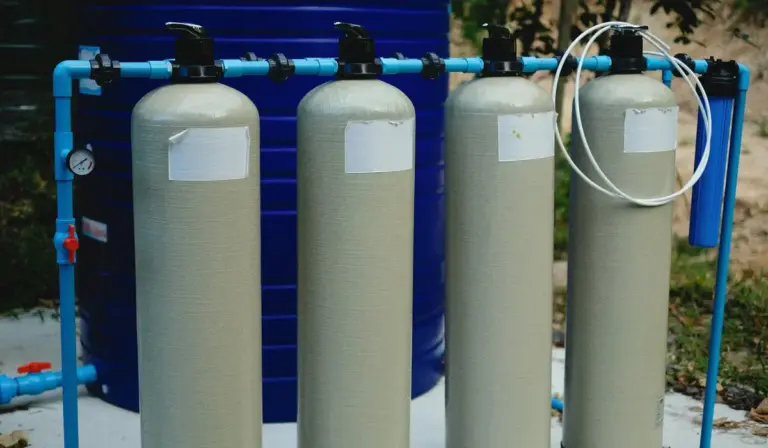 Aquarium canister filters connected with blue PVC piping and hoses.