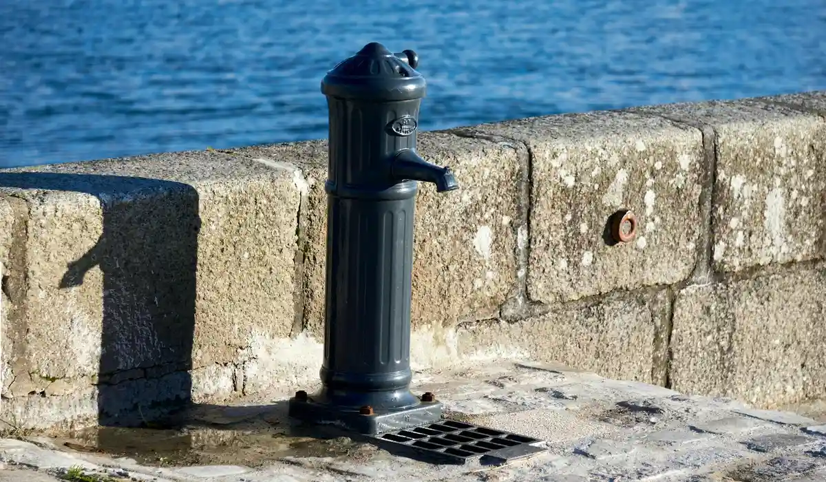 External water pump mounted on a concrete dock with blue water in the background