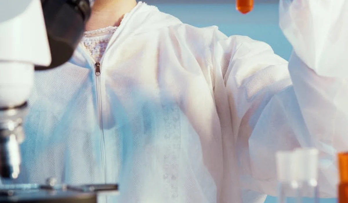 Lab technician in a white lab coat working with laboratory equipment