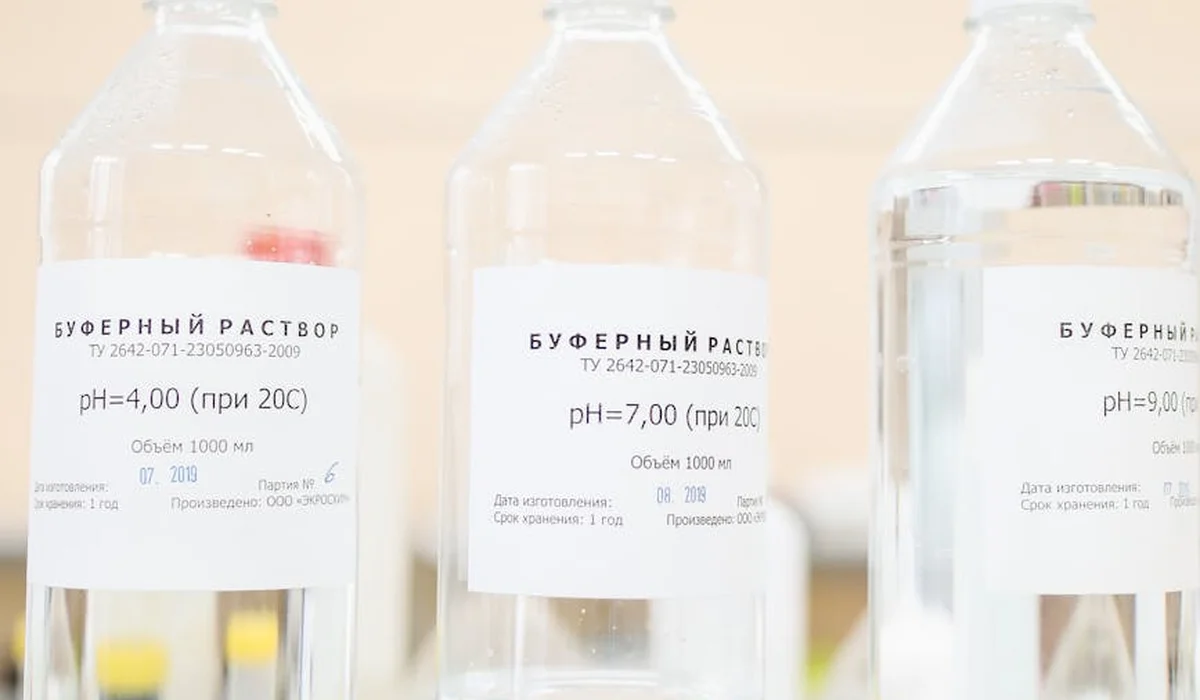 Three clear bottles with labels showing pH values (pH 4, pH 7, and pH 9) used as buffer solutions for aquarium pH testing.