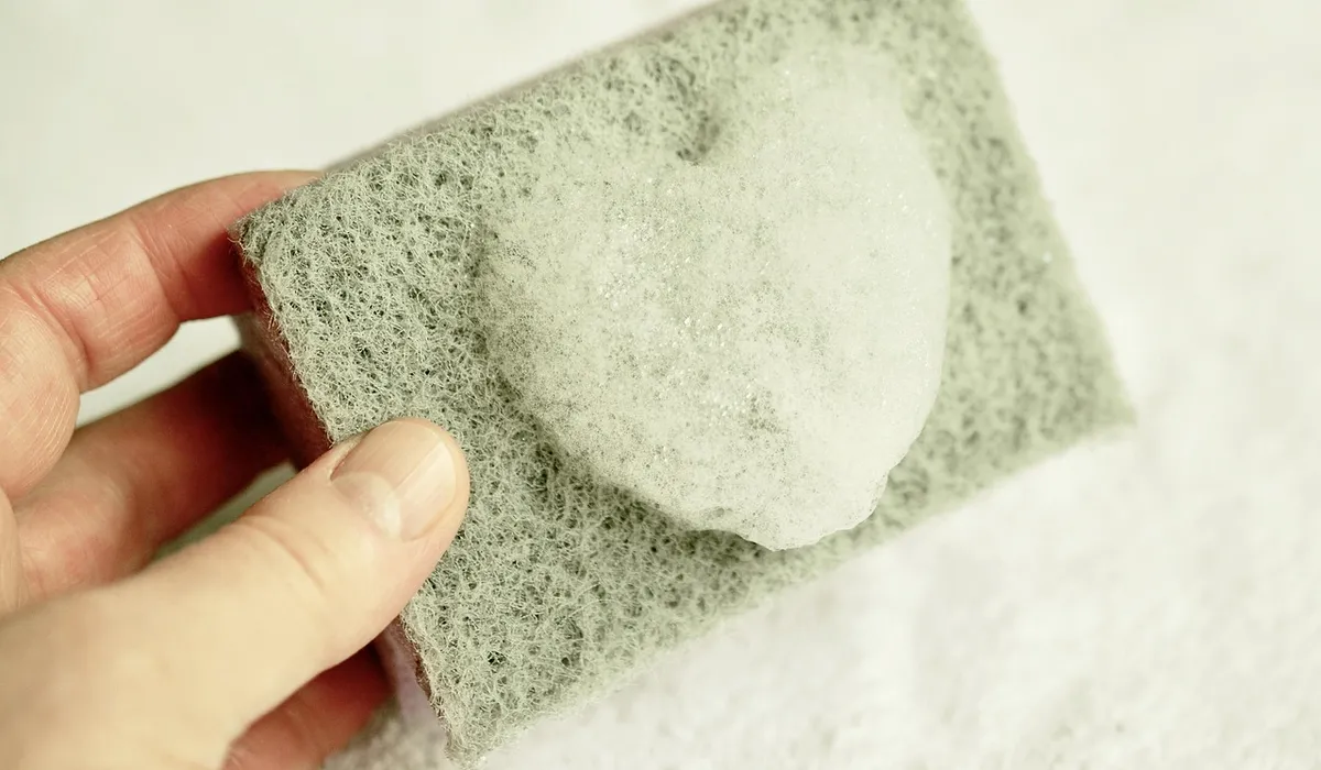 Close-up of a hand holding a porous sponge filter media used in planted aquariums.