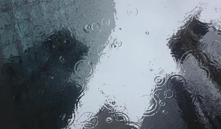 Close-up of a glass surface with raindrops and light reflections, symbolizing purified water for aquariums