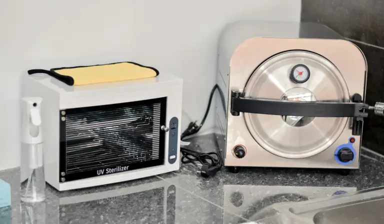 Two compact UV sterilizers on a dark countertop: a small rectangular unit labeled UV Sterilizer and a round stainless device nearby.
