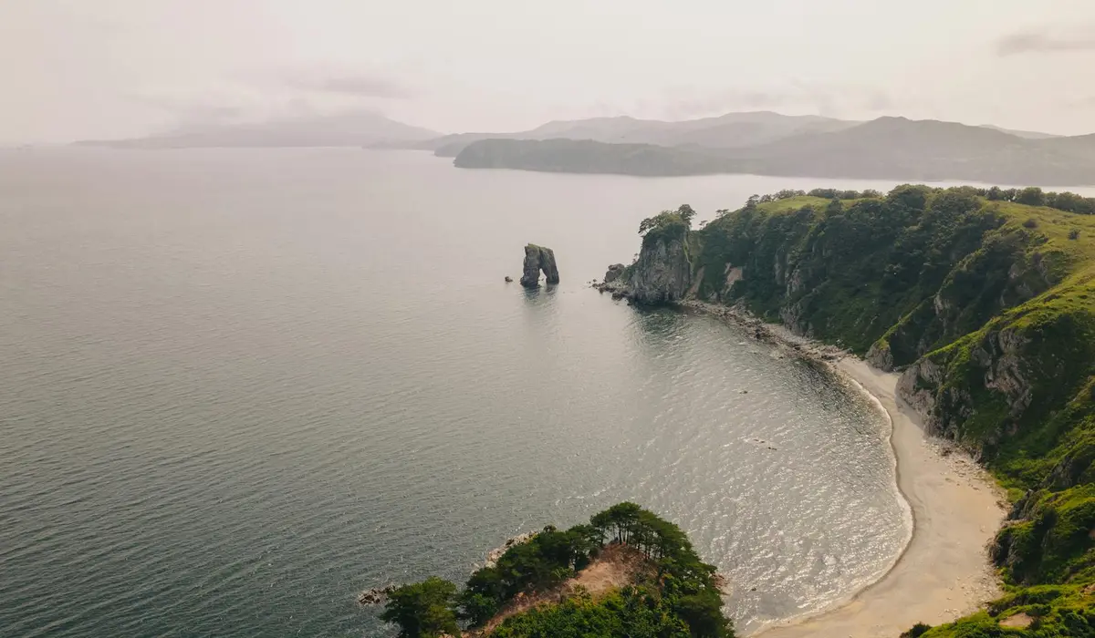 Coastal coastline with cliffs, a sandy beach, and calm ocean water